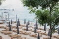 Deserted beach with sun loungers and folded umbrellas