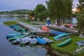 Deserted boat station at dusk. Pier by the water, lifebuoys and boats. Evening landscape