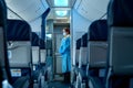 The deserted cabin of the plane, near the cockpit, a stewardess in a medical mask and a dressing gown will greet passengers. Air Royalty Free Stock Photo