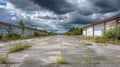 Deserted Factory Closed building with blocked windows, empty ground, tall weeds, dark sky clouds, abandoned industrial place, wide Royalty Free Stock Photo