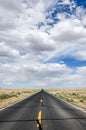 Deserted highway through the desert under cloudy sky Royalty Free Stock Photo