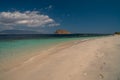 Deserted island coast scene in bright afternoon rock formation island in the ocean footsteps on the beach sand. Sumbawa Royalty Free Stock Photo