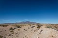 Deserted path in the New Mexico desert with an expansive view of mountain ridges under deep blue sky, Sevilleta