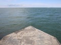 Deserted pier end on a calm summer seashore Royalty Free Stock Photo