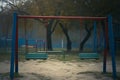 Deserted playground scene with a melancholic empty swing underlining isolation