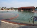 Deserted pool with clear clear water and standing on the opposite side of sun loungers and folded umbrellas from the sun