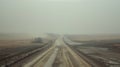 A deserted road disappearing into the horizon the smokecovered landscape creating an unsettling feeling of isolation and