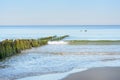 Deserted sea beach in evening. Soft wave and old wooden breakwater. Beautiful seascape, relaxation and tranquility. Selective