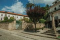 Old buildings behind stone wall with iron gate and pillory Royalty Free Stock Photo