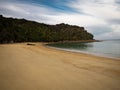 Deserted tropical pacific ocean sand beach surrounded by lush green nature in Abel Tasman National Park New Zealand Royalty Free Stock Photo