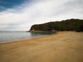 Deserted tropical pacific ocean sand beach surrounded by lush green nature in Abel Tasman National Park New Zealand Royalty Free Stock Photo