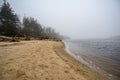 Deserted wild sandy beach in fog. Seashore in inclement weather Royalty Free Stock Photo