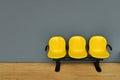 Deserted yellow seats on gray wall