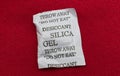 Desiccant silica gel on red background. Synthetic substance absorbing moisture Royalty Free Stock Photo