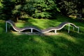 Design bench in the shape of a wavy line. wooden paneling on a metal galvanized frame. The bench is atypical to order in a city pa