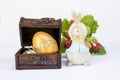 Design golden egg in treasure wooden box with funny wooden rabbit