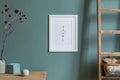 Mock up poster frame and interior accessories on the soft eucalyptus green wall.. Royalty Free Stock Photo