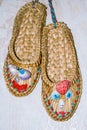 Design slippers of straw with a face made of shells
