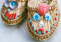 Design slippers of straw with a face made of shells. Faces Close up.