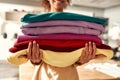 From design to delivery. Cropped shot of woman holding stack of colorful sweatshirts, hoodies while standing in the