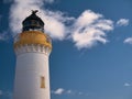 Designed by brothers David and Thomas Stevenson, Bressay Lighthouse on a sunny day, agains a blue sky with white clouds