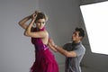 Designer adjusting dress back of fashion model in studio Royalty Free Stock Photo