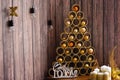 Designer Christmas tree with toys on a wooden background with candles and the inscription new year