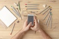 The designer draws a sketch in a notebook on a wooden table. Stationery. View from above Royalty Free Stock Photo