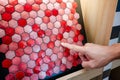 Designer hand pointing at red hexagon pattern mosaic tile on ceramic collection display shelf Royalty Free Stock Photo