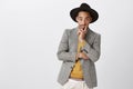 Designer looks at model in his clothes. Portrait of classy handsome young man in stylish formal outfit and hat, holding Royalty Free Stock Photo