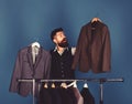 Designer makes choice near clothes hangers. Tailoring and design