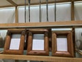 Designer natural teak wood photo frames on a glass shelf in a decor store. Ideas for a modern interior. Fashion decor