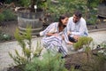 Designer people exterior in plant garden.Woman and man at beautiful plant garden working together