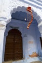 Designer setpiece hanging in front of traditional wooden door and blue coloured house of Jodhpur city, Rajsthan, India. Royalty Free Stock Photo