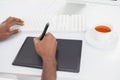 Designer using computer and digitizer with tea Royalty Free Stock Photo