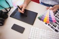 Designer using graphics tablet and colour charts Royalty Free Stock Photo