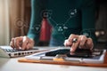 Designer using tablet with laptop and document on desk in modern office with virtual interface graphic icons network diagram. Royalty Free Stock Photo