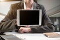 Designer using tablet with laptop and document on desk in the morning. Royalty Free Stock Photo