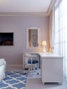 Designer white corner table by the window, with a mirror in the frame above and a chair near. Room for a teenager Royalty Free Stock Photo