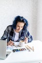 Designer working with colour palettes and laptop in her studio