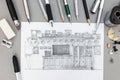 Designer workplace with freehand sketch of wall unit and various drawing tools