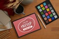 Designer workspace with mock up tablet, colour checker, painting tools and decorations