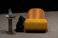 Designer yellow chair next to simple table in living room with work area next to the window Royalty Free Stock Photo