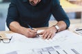 Designing buildings and spaces that are awe-inspiring. an unrecognizable male architect working on a design.