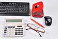 On the Desk of the accountant: invoice, keyboard, calculator, mouse, hole punch, glasses and red pen Royalty Free Stock Photo