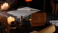 Desk with aged paper sheets and feather pen. Vintage quill pen laying on old parchment, inkwell box with stamps and Royalty Free Stock Photo