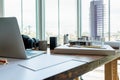 Desk of Architect and Interior designer in bright home office with building model, laptop, camera and other equipment messy for Royalty Free Stock Photo