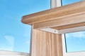 Desk with bleached solid oak stands on a cork floor against the sky outside the window