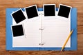 Photo album on a wood desk background with several polaroid frame photo prints, copy space Royalty Free Stock Photo