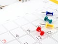 four colorful thumbtack on opened desk calendar page Royalty Free Stock Photo